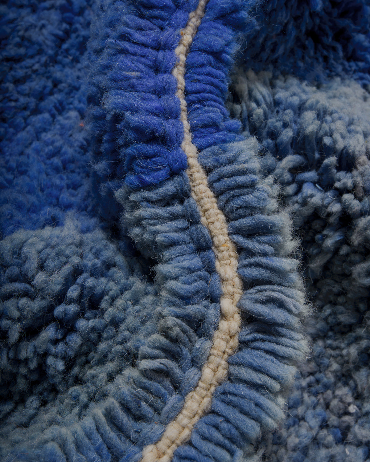 Close up of wool rug in two different shades of blue.